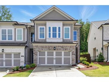 Charming two-story townhome featuring a brick facade, two-car garage, and well-manicured lawn in a desirable neighborhood at 116 Birch Tree Way, Cumming, GA 30040