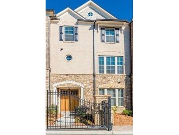 Charming multi-story townhouse with stone accents, gated entrance, and classic architectural details at 1435 Druid Manor, Atlanta, GA 30329