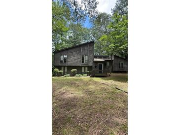 Contemporary-style home with a two-story façade, wood siding, front yard, and large windows at 361 Gordon Valley Sw Ln, Mableton, GA 30126
