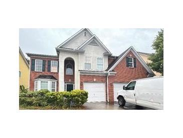 Two-story brick home with a two-car garage and manicured landscaping at 3525 Park Hill Cir, Loganville, GA 30052