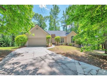 Charming single-story home featuring a well-maintained lawn, mature trees, and an attached two-car garage at 616 Lone Oak Ct, Lithonia, GA 30058