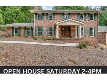 Two-story brick home with green shutters, manicured landscaping, and an inviting covered front porch at 2592 River Oak Dr, Decatur, GA 30033