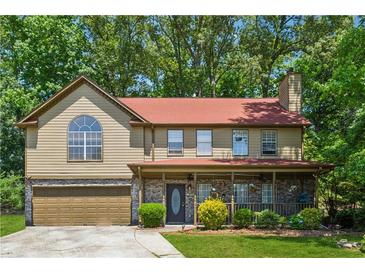 Charming two-story home featuring a covered front porch, attached garage and well-maintained landscaping at 475 Shadetree Ln, Lawrenceville, GA 30044