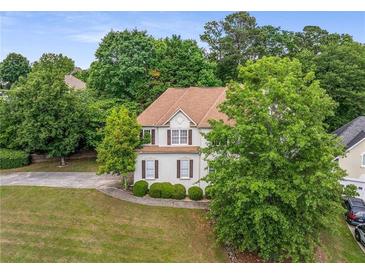 Charming two-story home featuring a well-manicured front yard and a classic design with beautiful landscaping at 600 Oakmont Hl, Duluth, GA 30097