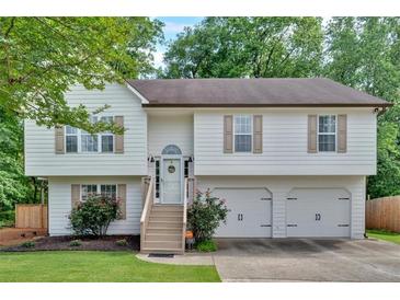 Charming two-story home featuring a well-maintained front yard and an attached two-car garage at 4053 Five Oaks Ct, Powder Springs, GA 30127
