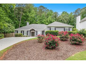 Charming one-story home with landscaped front yard and blooming flowers, offering great curb appeal at 703 Kirkwood Cir, Woodstock, GA 30189
