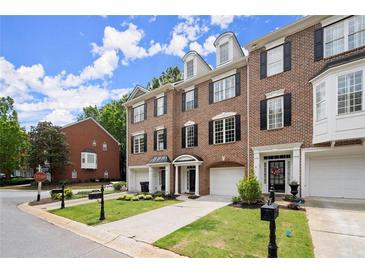 Charming brick townhomes featuring manicured lawns, garages, and inviting curb appeal at 2303 Waters Edge Trl, Roswell, GA 30075