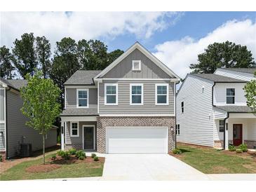 Charming two-story home featuring a gray exterior, brick accents, and a two-car garage at 407 Newland Way, Acworth, GA 30102