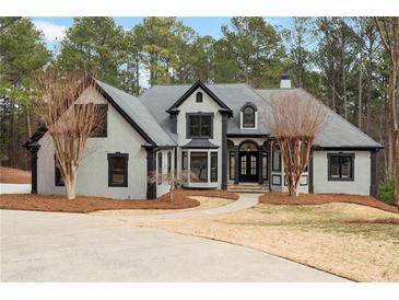 Stunning two-story home featuring a manicured lawn and inviting entryway with classic gray and black design elements at 1066 Fairway Valley Dr, Woodstock, GA 30189