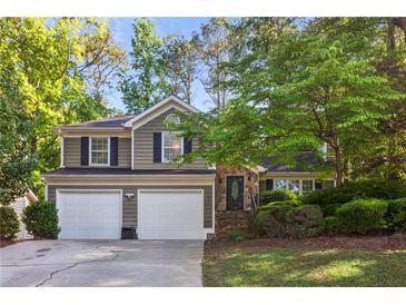 Charming two-story home with a two-car garage and beautifully landscaped front yard at 4856 Saddlerun Ln, Powder Springs, GA 30127