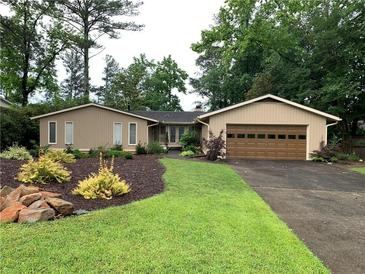 Charming single-story home boasts lush landscaping, healthy lawn and an attached garage at 4040 Summit Dr, Marietta, GA 30068
