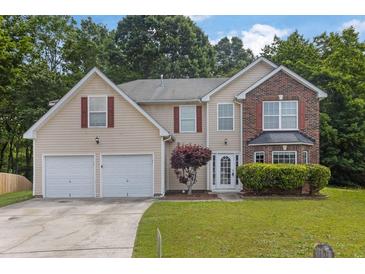 Charming two-story home featuring a blend of vinyl siding and brick accents, complemented by a well-manicured front yard at 6032 Trotters Cir, Fairburn, GA 30213