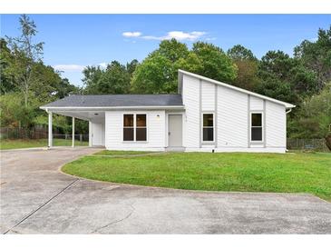 Charming single-story home with modern architectural details, grassy front yard, and convenient carport at 1070 Kirkland Rd, Covington, GA 30016
