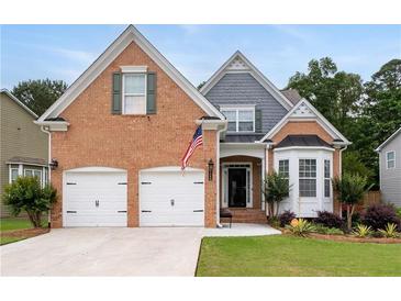 Charming brick home with well-manicured lawn, two-car garage, and inviting front porch at 3480 Arbroath Dr, Douglasville, GA 30135
