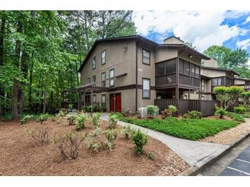 Charming home featuring lush landscaping, mature trees, and a well-maintained lawn at 504 River Run Dr, Atlanta, GA 30350