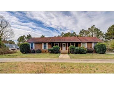 Charming single story home featuring a well-maintained lawn, mature trees, and a classic facade at 5687 Highway 212, Covington, GA 30016