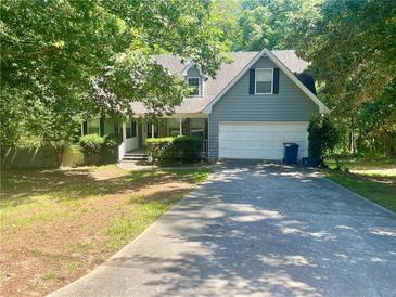 Charming home with two-car garage and partially shaded front yard in a peaceful, wooded setting at 1075 Crystal Water Dr, Lawrenceville, GA 30045