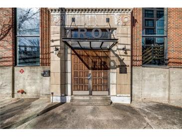 Stately stone and brick building entrance featuring wood doors and transom with industrial details at 650 Glen Iris Drive Ne # 27, Atlanta, GA 30308