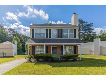 Charming two-story home features a classic design and well-maintained front yard at 7623 Mcgillicuty Dr, Union City, GA 30291