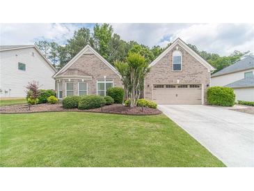 Charming brick home featuring a well-manicured lawn and an attached two-car garage at 1657 Williams Mill Way, Dacula, GA 30019