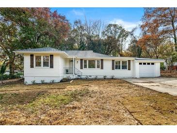 Charming renovated ranch-style home with white siding, a well-maintained lawn, and a single car attached garage at 2376 Cross Nw St, Atlanta, GA 30318