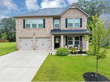 Charming two-story brick home featuring a manicured lawn and a welcoming front porch at 201 Kingfisher Walk, Covington, GA 30014