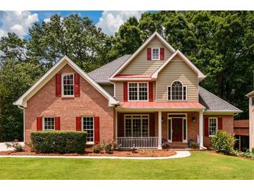 Charming brick home with manicured lawn, red shutters, and inviting front porch at 2430 Harbin Springs Cv, Dacula, GA 30019