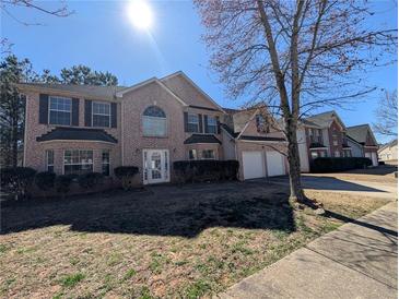 Charming two-story brick home with attached two car garage and well-maintained front lawn at 5622 Platte Dr, Ellenwood, GA 30294