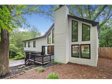 Beautifully renovated exterior with large windows and a charming front deck entrance at 104 River Creek Dr, Woodstock, GA 30188