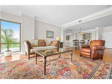 Bright living room with large windows, hardwood floors, and an ornate oriental rug and an adjacent dining room at 3475 Oak Valley Ne Rd # 950, Atlanta, GA 30326