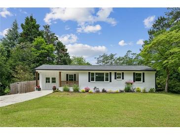 Charming renovated ranch-style home featuring a freshly painted white brick exterior and a well-manicured lawn at 1477 Spruce Se Dr, Smyrna, GA 30080