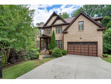 Beautiful brick home showcasing a well-manicured lawn, mature trees, and an attached two-car garage at 3301 Chastain Ridge Dr, Marietta, GA 30066