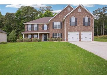 Charming two-story brick home with a well-manicured lawn and attached two-car garage at 4549 Clarks Creek Ter, Ellenwood, GA 30294