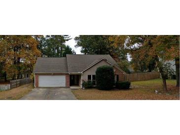 Charming single-Gathering home featuring a brick facade and attached garage, nestled among mature trees and a well-manicured lawn at 4262 Apache Se Dr, Acworth, GA 30102