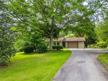 Charming single-story home with a well-maintained lawn, mature trees, and a paved driveway at 4380 Highway 138, Oxford, GA 30054