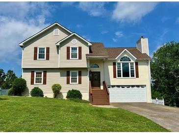 Two-story home with vinyl siding, brown shutters, and a well-manicured front lawn on a sunny day at 19 Magnolia Ne Ct, Rydal, GA 30171