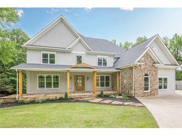 Stunning two-story home featuring a stone facade and inviting covered front porch at 2555 Chattahoochee Ln, Cumming, GA 30041
