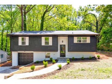 Stylish two-story home with a gray exterior, a front yard, and a garage at 809 Vinton Wood Rd, Forest Park, GA 30297