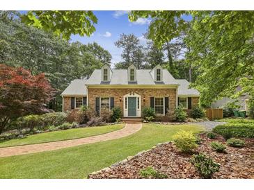 Charming brick home featuring manicured landscaping, dormer windows, and a welcoming walkway to the front door at 95 Brandon Ridge Dr, Atlanta, GA 30328