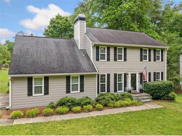 Charming two-story home featuring gray siding, black shutters, landscaped yard, and a classic chimney at 2166 Carlyle Dr, Marietta, GA 30062