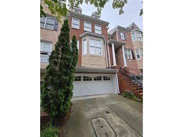 Charming multi-story brick home featuring an attached two-car garage and well-maintained landscaping at 1042 Emory Parc Pl, Decatur, GA 30033