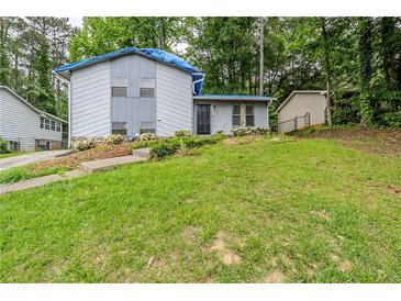 View of the home with a grassy front yard, front entry, and partial roof repair at 2347 Fairway Sw Cir, Atlanta, GA 30331