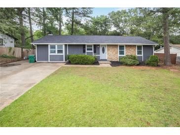 Charming home boasts a well-manicured lawn, stone accents, and a welcoming front entrance at 4448 Denise Dr, Decatur, GA 30035