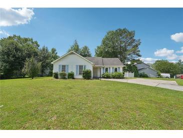Charming single-story home with a lush green lawn and light blue shutters on a sunny day at 742 Redland Dr, Jonesboro, GA 30238
