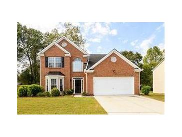Charming two-story brick home with a well-manicured lawn and attached two-car garage at 2715 Haynes Club Circle, Grayson, GA 30017