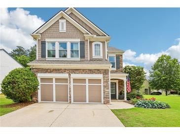 Charming two-story home with a stone and shingle facade, an attached two-car garage and a well-manicured lawn at 5225 Stonehaven Vw, Cumming, GA 30040