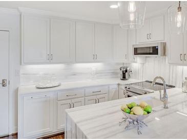 Bright white kitchen with marble countertops, stainless steel appliances, and modern pendant lighting at 300 Johnson Ferry Ne Rd # A706, Atlanta, GA 30328