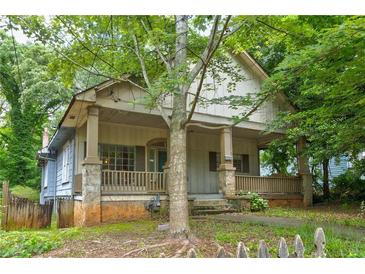 Charming craftsman-style home with a covered porch, stone accents, and mature trees providing shade at , Atlanta, GA 30310