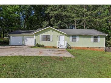 Charming single-story home with an attached two-car garage and a well-maintained front yard at 4954 Browns Mill Rd, Lithonia, GA 30038