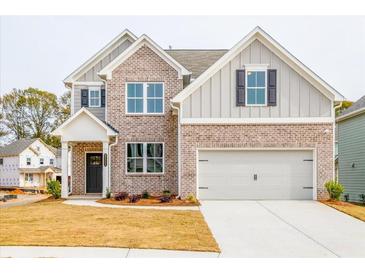 Charming two-story home featuring a brick and gray facade, a two-car garage, and a well-manicured lawn at 1730 Fulmont Cir, Mableton, GA 30126